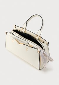 Sac à main blanc texturé avec garniture noire, deux poignées supérieures, ferrures dorées, et un foulard à motifs décorant la fermeture éclair.