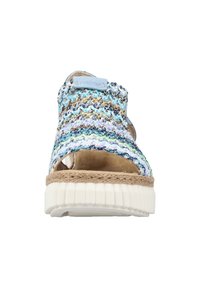 Sandale en tissu tissé avec un motif multicolore en bleu et beige, semelle de style espadrille avec un fond en caoutchouc texturé blanc.