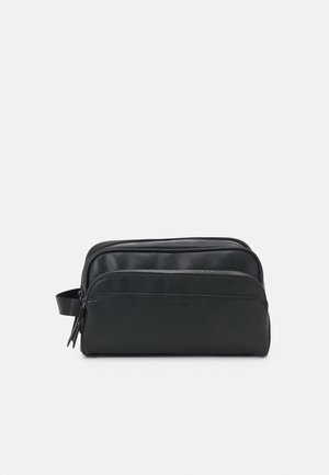 Schwarze Reisetasche mit einem glatten Lederfinish, rechteckiger Form und seitlichem Griff. Verfügt über ein vorderes Reißverschlussfach.