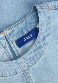 Hele sinine teksariidest rõivakaelus, mille sees on nähtav tumesinine brändisilt tekstiga "JJXX".