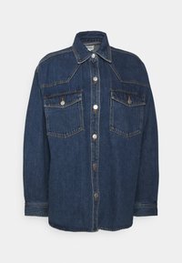 Jeansjacka i mörkblått med knäppning, två bröstfickor, spetsig krage och kontrasterande sömmar på axlarna och fickorna.