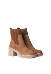 Stivaletti ankle in suede marrone con un pannello in maglia a coste marrone, tacco a blocco spesso e dettagli di cucitura bianca a contrasto.