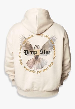 Cream-colored hoodie featuring a graphic of a bird with spread wings and circular text that reads "Drop Size" in black and gold accents.