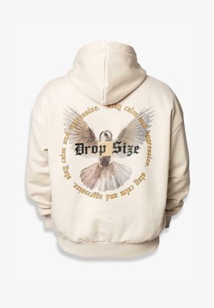 Cremfarvet hoodie med et grafisk motiv af en fugl med udbredte vinger og cirkulær tekst, der står "Drop Size" i sort og guld accenter.