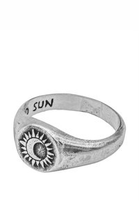 Sudraba gredzens ar saules motīvu, apaļu virsmu un fakturētu stīpu. Iekšpusē uzraksts "TO SUN". Gluda virsma ar detalizētiem akcentiem.