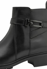 Botín de cuero negro hasta el tobillo con un diseño elegante, que incluye una correa decorativa, costuras sutiles y un tacón bajo y cuadrado.