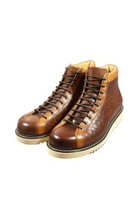 Stivaletti stringati in pelle marrone con trama intrecciata, dettagli in marrone chiaro a contrasto, punta tonda e suola in gomma color crema.