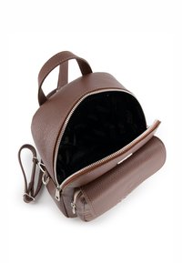 Brun tekstureret læderrygsæk med to lynlåskompartments, frontlomme med lynlås og indvendig branding. Justerbar skulderrem medfølger.