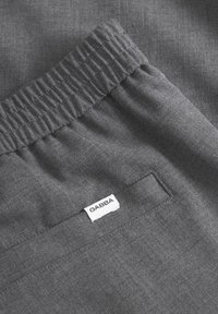 Hallid hallid kangast dressipüksid elastse vöökohtaga ja väikese valge sildiõmblusega küljes. Silene tekstuur ja lihtne disain.