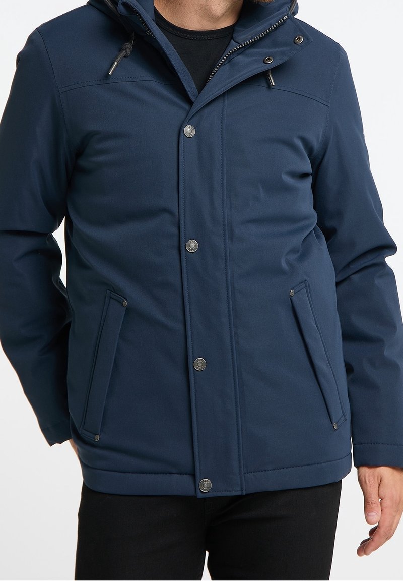 Veste imperméable bleu marine avec une capuche zippée, des boutons-pression, deux poches avant et un tissu lisse et texturé.