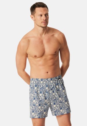 Blauw gebloemde zwemshorts met een bloemmotief in crèmekleuren en blauw, een elastische tailleband en een losse pasvorm.