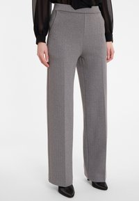 Grijze wijde broek met verticale strepen, gemaakt van gestructureerde stof. Heeft een aangesloten taille en een slanke silhoet.