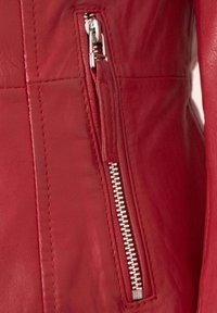 Rote Lederjacke mit seitlichem Reißverschluss und silbernen Beschlägen. Verfügt über detaillierte Nähte und eine glatte Textur.
