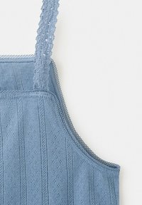 Canotta azzurro chiaro lavorata a maglia con spalline e bordi rifiniti in pizzo, caratterizzata da motivi verticali in rilievo.