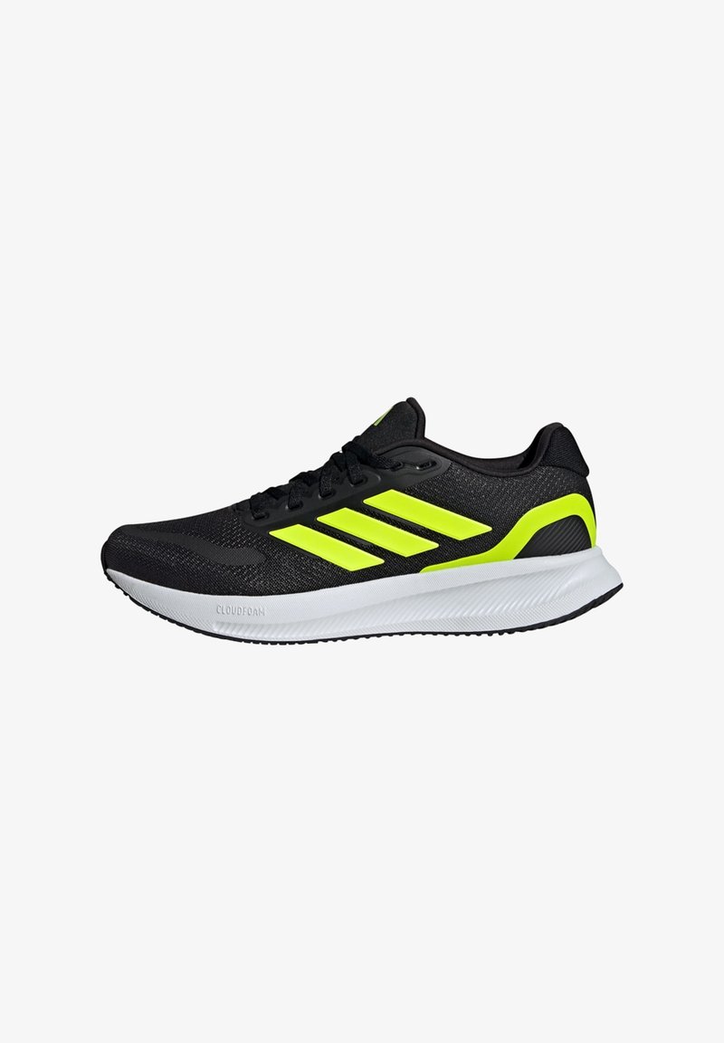 Scarpe sportive nere con una parte superiore in mesh traspirante, caratterizzate da tre strisce gialle brillanti, una suola intermedia bianca e una suola nera testurizzata.