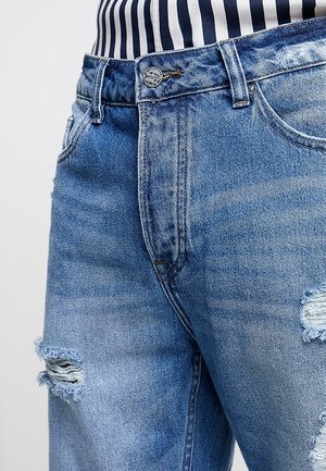 Jasnoniebieskie dżinsy z denimu z przetarciami, standardowym pasem i klasycznym projektem z pięcioma kieszeniami oraz srebrnymi okuciami.