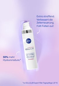 White cylindrical serum container with pump, silver cap, blue logo, and label text in multiple languages on a soft purple background.