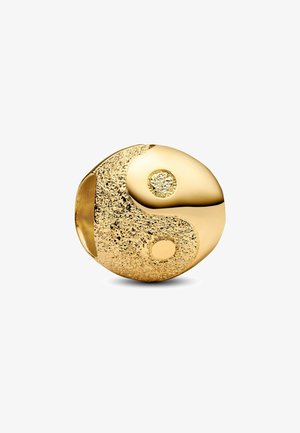 Charm yin-yang in tono oro con una metà liscia e una metà texturizzata e maculata, arricchita da due accenti circolari contrastanti. Forma arrotondata.