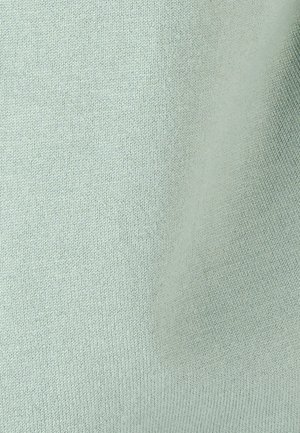 Lichtgrijze gebreide stofstructuur met fijne, uniforme stiksels en zachte plooien zichtbaar aan de rechterkant.