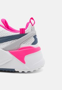 Vit sportskor med en överdel av mesh, prydda med rosa detaljer, en grå inramning runt hälen och en texturerad gummisula.