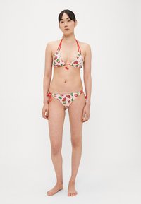 Strój bikini o różowej bazie z nadrukiem czereśni. Trójkątny top z czerwonymi troczkami i małym detalem w kształcie czereśni; regulowane dopasowane majtki.
