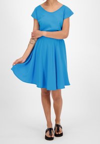 Vestido azul de manga corta con escote redondeado y cintura elástica, que presenta una falda acampanada. La tela parece suave y ligera.