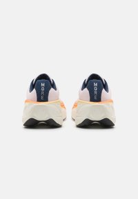 Zapatillas de running que presentan una mezcla de degradados en rosa claro y naranja, detalles en azul marino y una suela texturizada con una prominente etiqueta "MORE" en el talón.