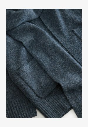 Cárdigan de punto azul oscuro hecho de lana suave, con puños acanalados y bolsillos, y un acabado suave y texturizado.
