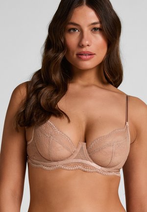 Lace bh met een zachte beige kleur, semi-transparante cups en ingewikkelde bloemmotieven. Voorzien van verstelbare bandjes en een geschulpte rand.