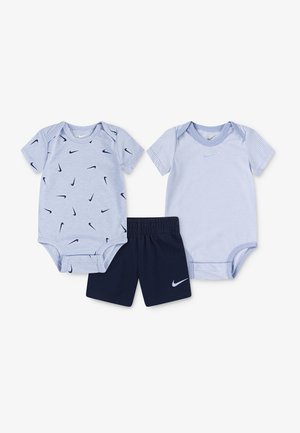Deux bodys pour bébé Nike bleu clair—l'un avec un motif de virgule bleu marine, l'autre avec de fines rayures—et un short Nike bleu marine avec le logo virgule.