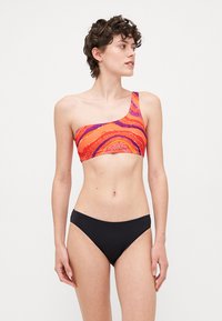 Μπικίνι τοπ με έναν ώμο σε έντονο πορτοκαλί και ροζ σχέδιο με κυματιστές σχεδιάσεις, συνδυασμένο με μονοχρώμια μαύρα μπικίνι κάτω. Λείο ύφασμα.