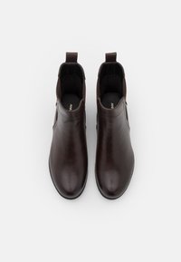 Bottines en cuir brun au fini lisse, avec des panneaux latéraux élastiques, des languettes de tirage et des bouts arrondis. Design minimaliste, sans élément métallique visible.