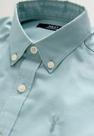 Hellblaues Hemd mit Kragen und Knopfleiste, aus gewebtem Stoff. Verfügt über weiße Knöpfe und eine dezente Logo-Stickerei am Saum.