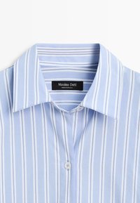 Hellblaues Hemd mit weißen und dunkleren blauen vertikalen Streifen, Button-Down-Kragen und einem schwarzen Etikett mit der Aufschrift "Massimo Dutti". Weiche Baumwollstruktur.