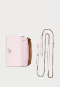 Light pink leather handbag with a textured finish, a gold logo, and a single metallic chain strap alongside additional leather straps.