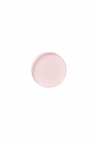 Rund, grund tallrik i en mjuk rosa nyans med en slät, matt yta och subtilt svängda kanter, utformad för servering eller som dekoration.
