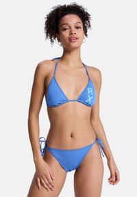 Bikini bleu comprenant un haut triangle avec des bretelles ajustables à nouer, et un bas à nouer sur les côtés, fabriqué en tissu lisse et extensible.