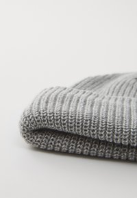 Grå strikket beanie med et tekstureret ribmønster, der har en foldet manchet og blødt, fleksibelt garn for komfort og varme.