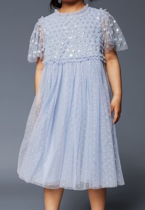 Robe bleu clair avec un corsage en tulle texturé à pois, des manches bouffantes courtes et une jupe fluide avec des couches de tulle et des embellissements dispersés.