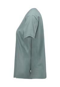 Helles grünes T-Shirt mit kurzen Ärmeln, das einen entspannten Schnitt, eine glatte Baumwollbeschaffenheit und ein kleines Markentag an der Seitennaht aufweist.