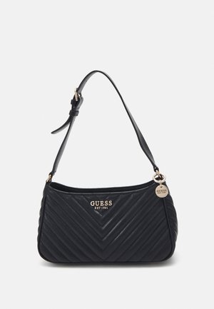 Sort quiltet skuldertaske med gyldent "GUESS EST 1981" logo og justerbar rem med guldfarvet spænde og rund charme.
