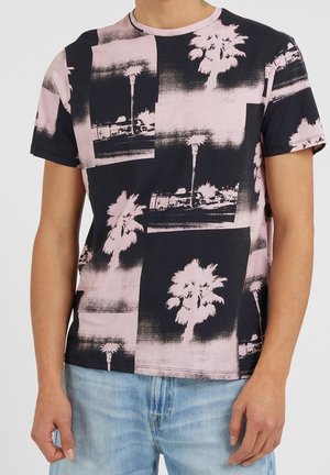 T-shirt à manches courtes avec un motif graphique de palmiers noirs et roses sur un fond uni. Fabriqué en coton doux avec une coupe décontractée.