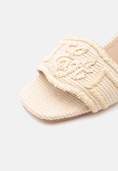 Πλεκτό ανοιχτό πέδιλο σε μπεζ χρώμα με τετράγωνη μύτη και πλεγμένο λουράκι από ραφία με υφή κεντήματος λουλουδιών.