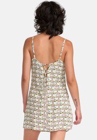 Vestido corto con tirantes finos, que presenta una tela estampada en colores pastel y un detalle de lazo en la parte posterior.
