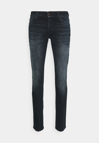 Jeans de denim preto em corte slim, com lavagem desbotada, cinco bolsos e um botão de destaque vermelho. Design de perna reta com bainha padrão.
