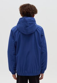 Blaue, leichte Jacke mit Kapuze und elastischen Bündchen. Hat eine glatte Textur und eine lockere Passform. Die Rückansicht zeigt ein gerafftes Saumdetail.