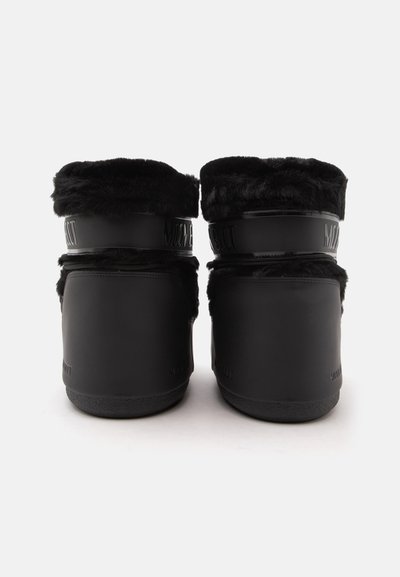 Paire de bottes d'hiver noires avec doublure en fourrure rabattue sur le dessus, vues de dos sur fond blanc.