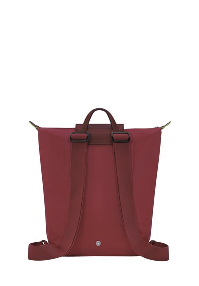 Maroon backpack made of durable fabric with brown leather accents, adjustable straps, top handle, and metallic hardware.