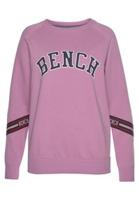 Rosa sweatshirt med svart "BENCH"-logotyp över bröstet och randiga detaljer på ärmarna. Ribbad mudd och nederkant. Mjukt, texturerat tyg.