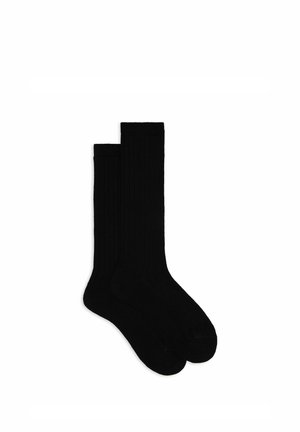 Calzini neri a coste con una trama liscia, caratterizzati da una lunghezza classica al polpaccio e da punta e tallone rinforzati per una maggiore durata.